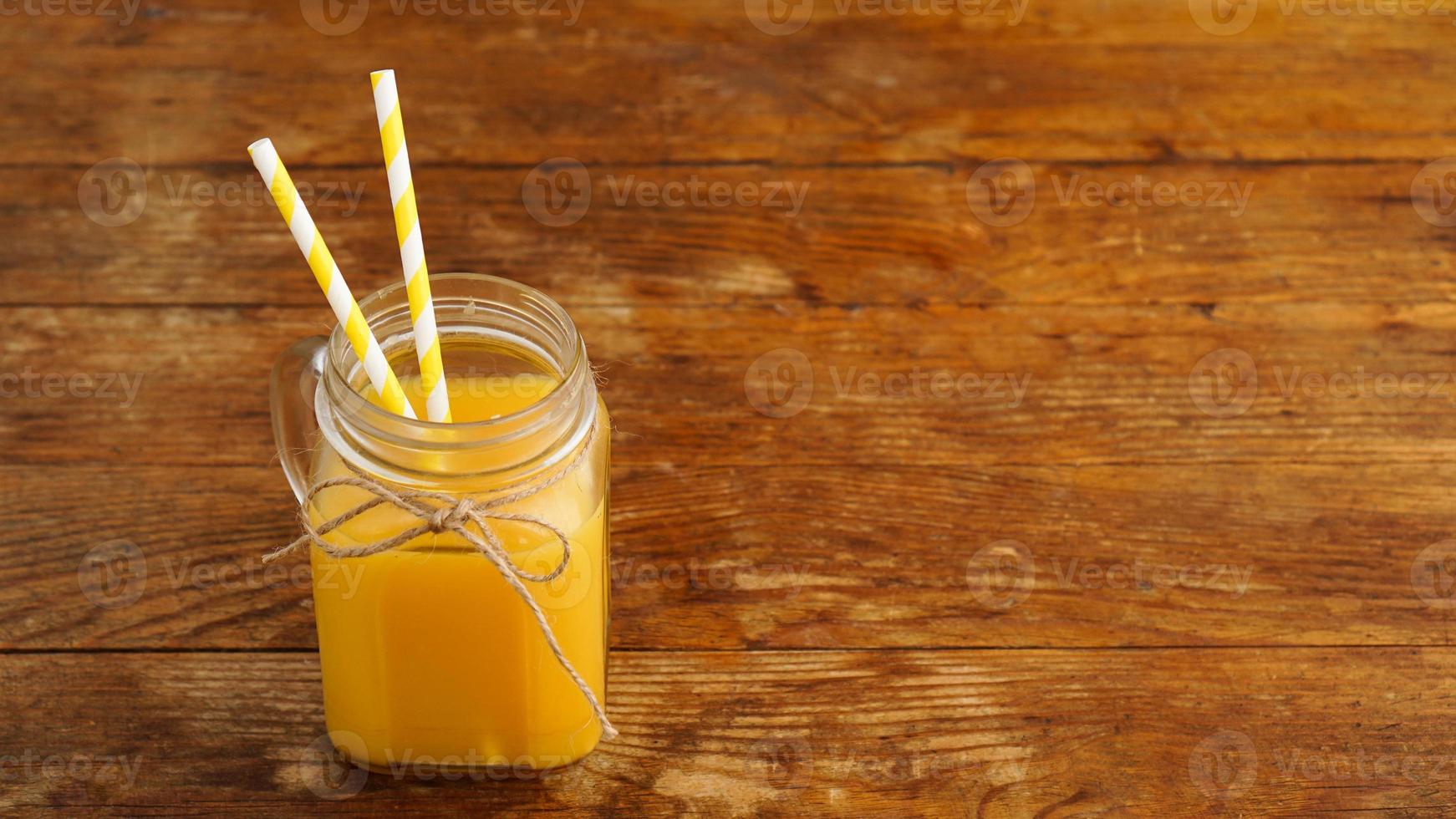 Fresh orange juice on wooden table photo