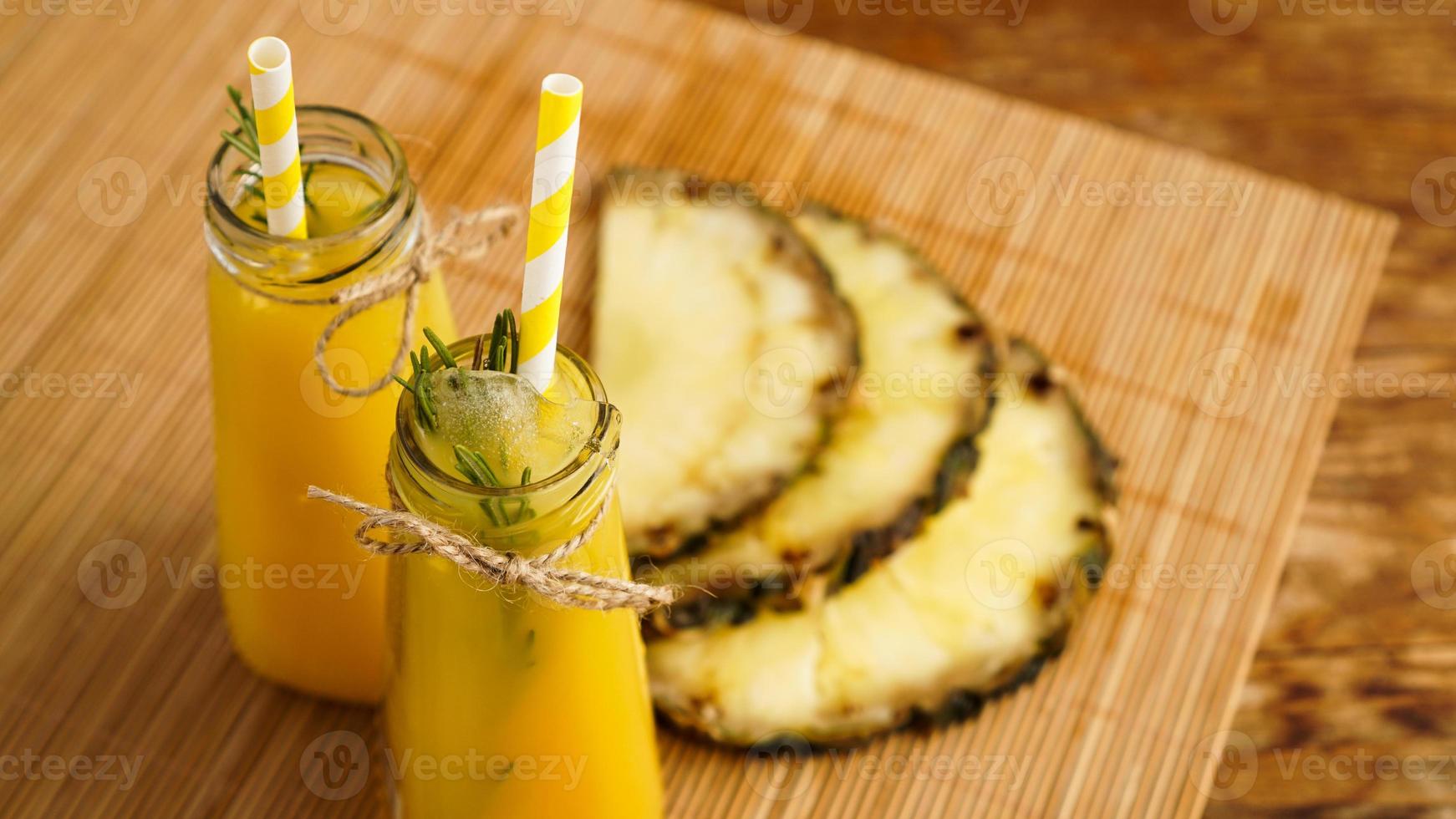 Fresh made Pineapple Juice with Ice in a small glass bottle photo