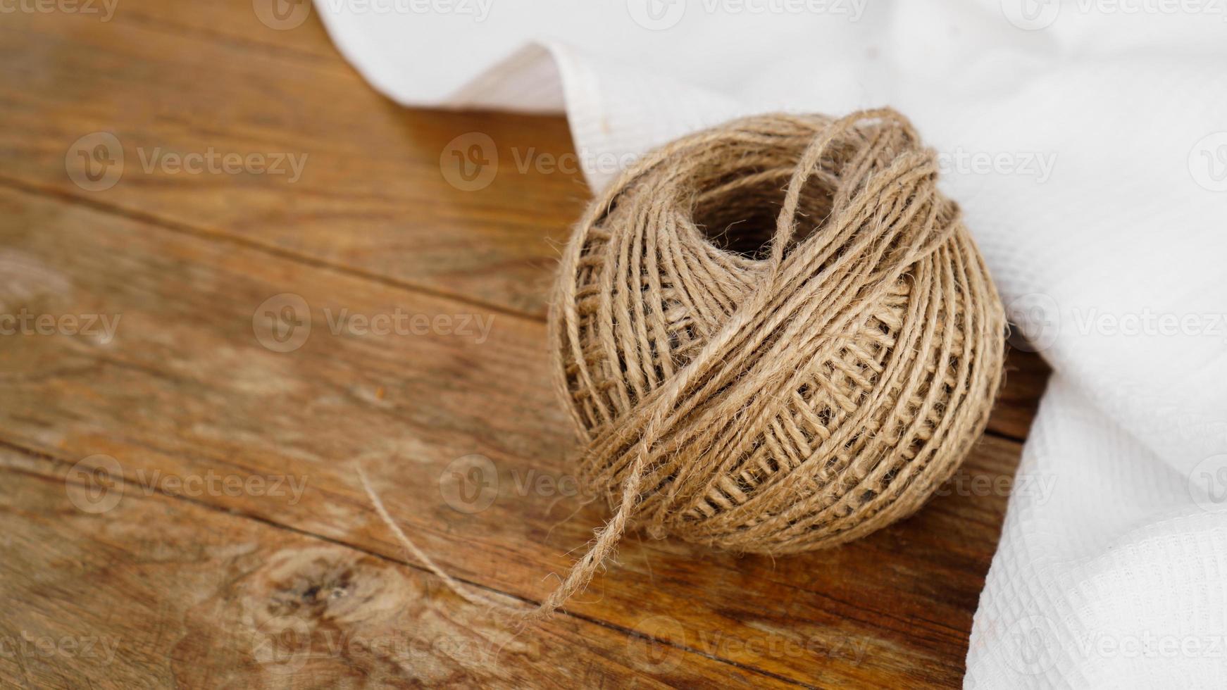 Skeins of jute rope on wooden table flat lay background photo