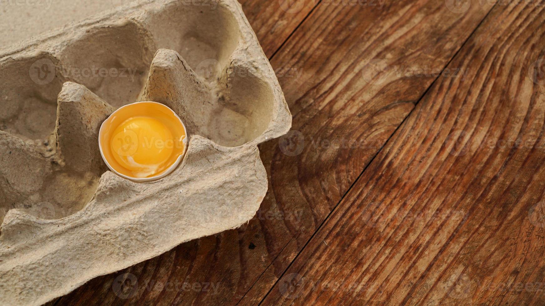 One broken egg in a cardboard egg tray. Half egg photo