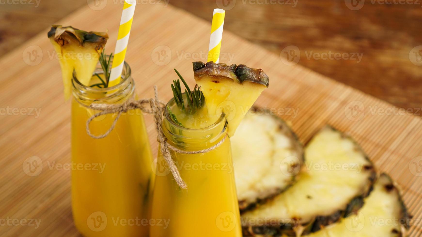 jugo de piña recién hecho con hielo en una pequeña botella de vidrio foto