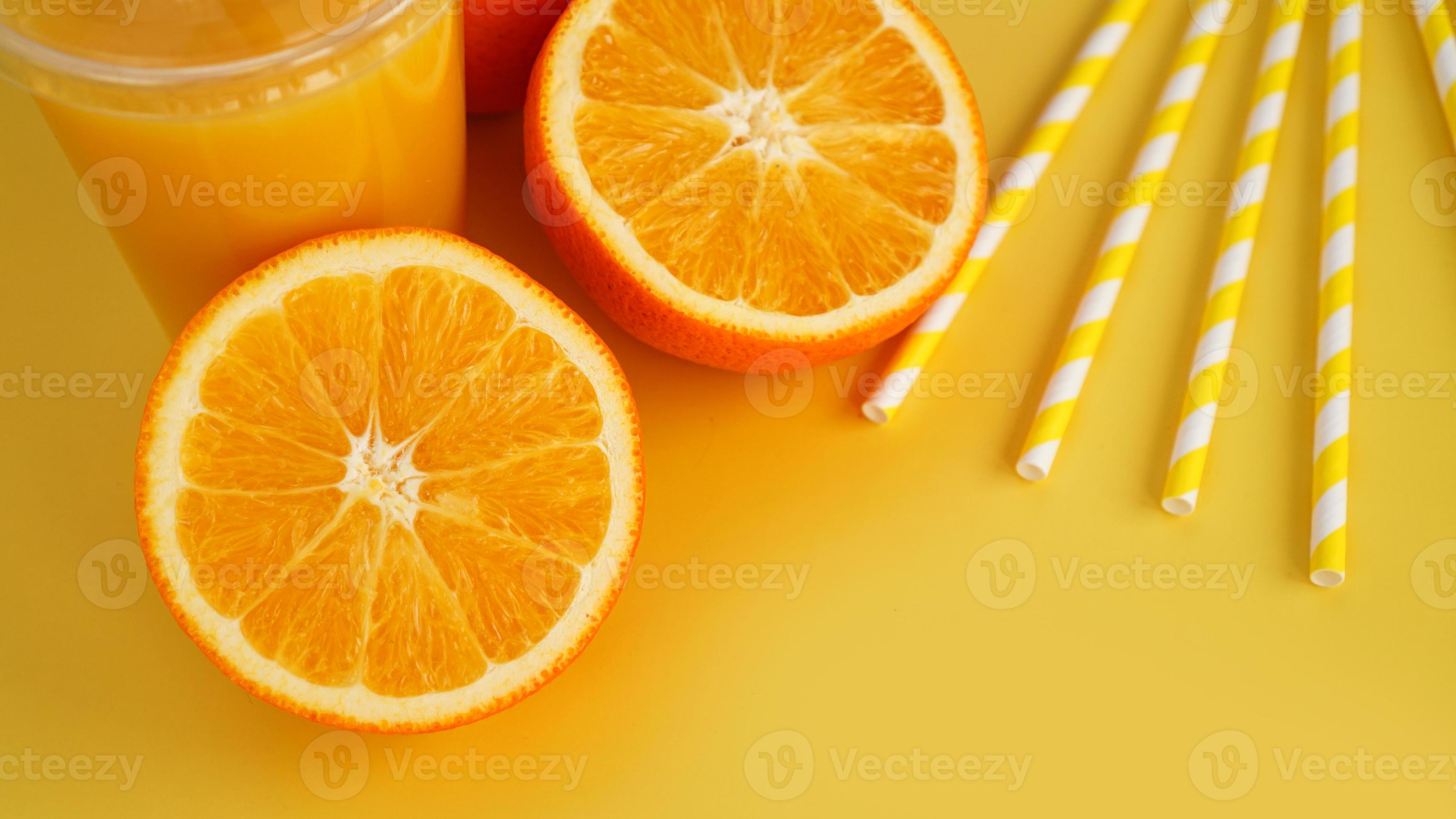 Jugo de naranja en comida rápida taza cerrada con tubo sobre fondo amarillo foto