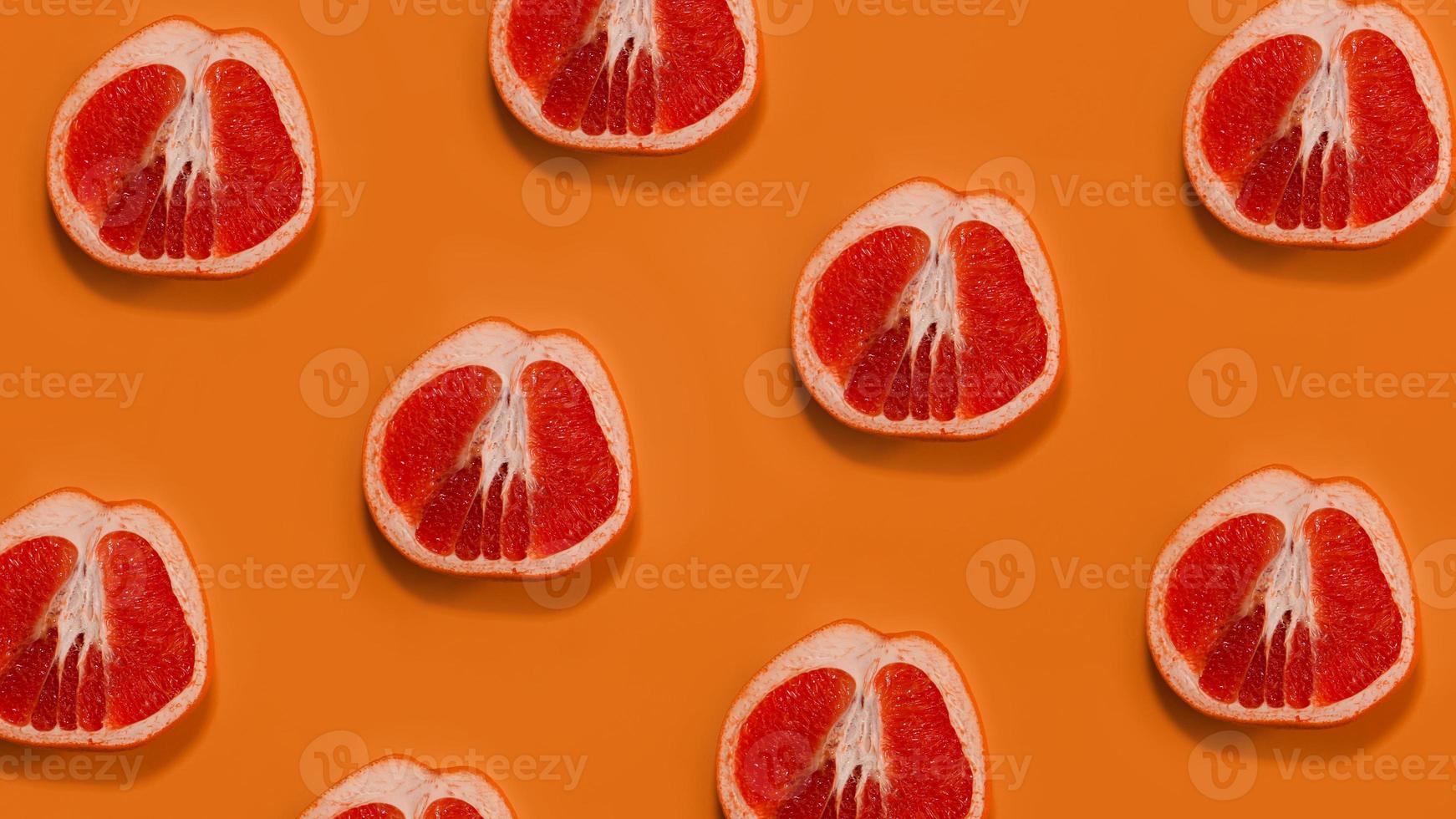 Grapefruit pattern on orange background. Minimal flat lay concept photo