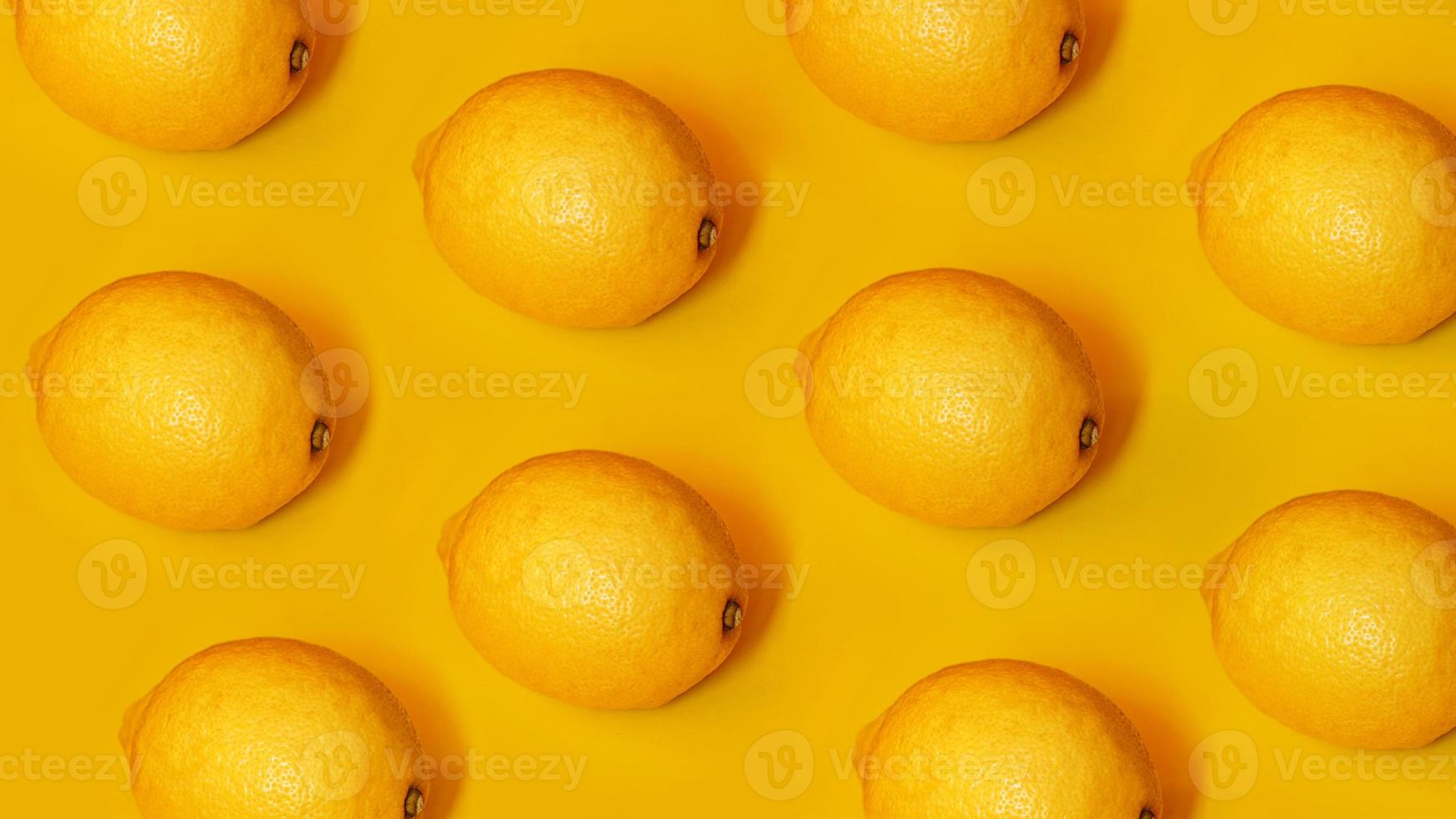 Patrón de alimentos con limones sobre fondo de papel amarillo foto