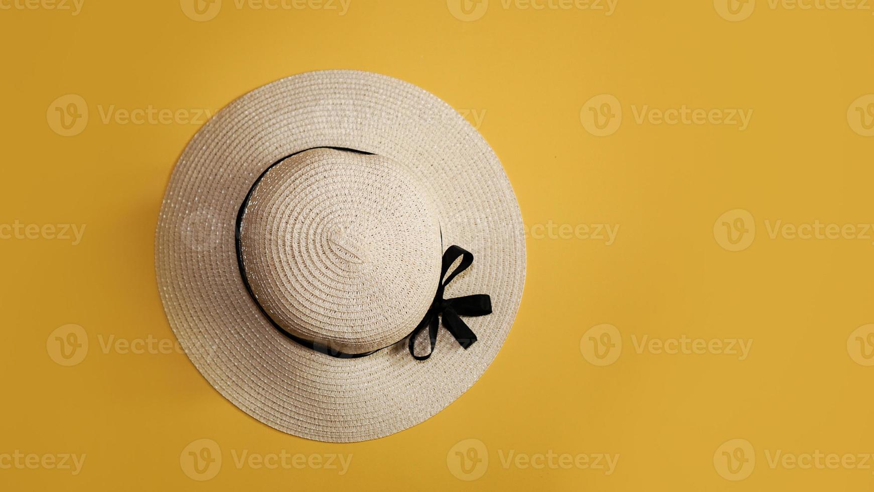 Summer straw hat on yellow background top view flat lay copy space. photo