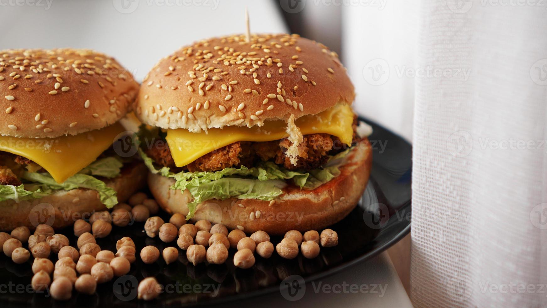 hamburguesa de verduras con chuleta de garbanzos. dos hamburguesas en plato negro foto