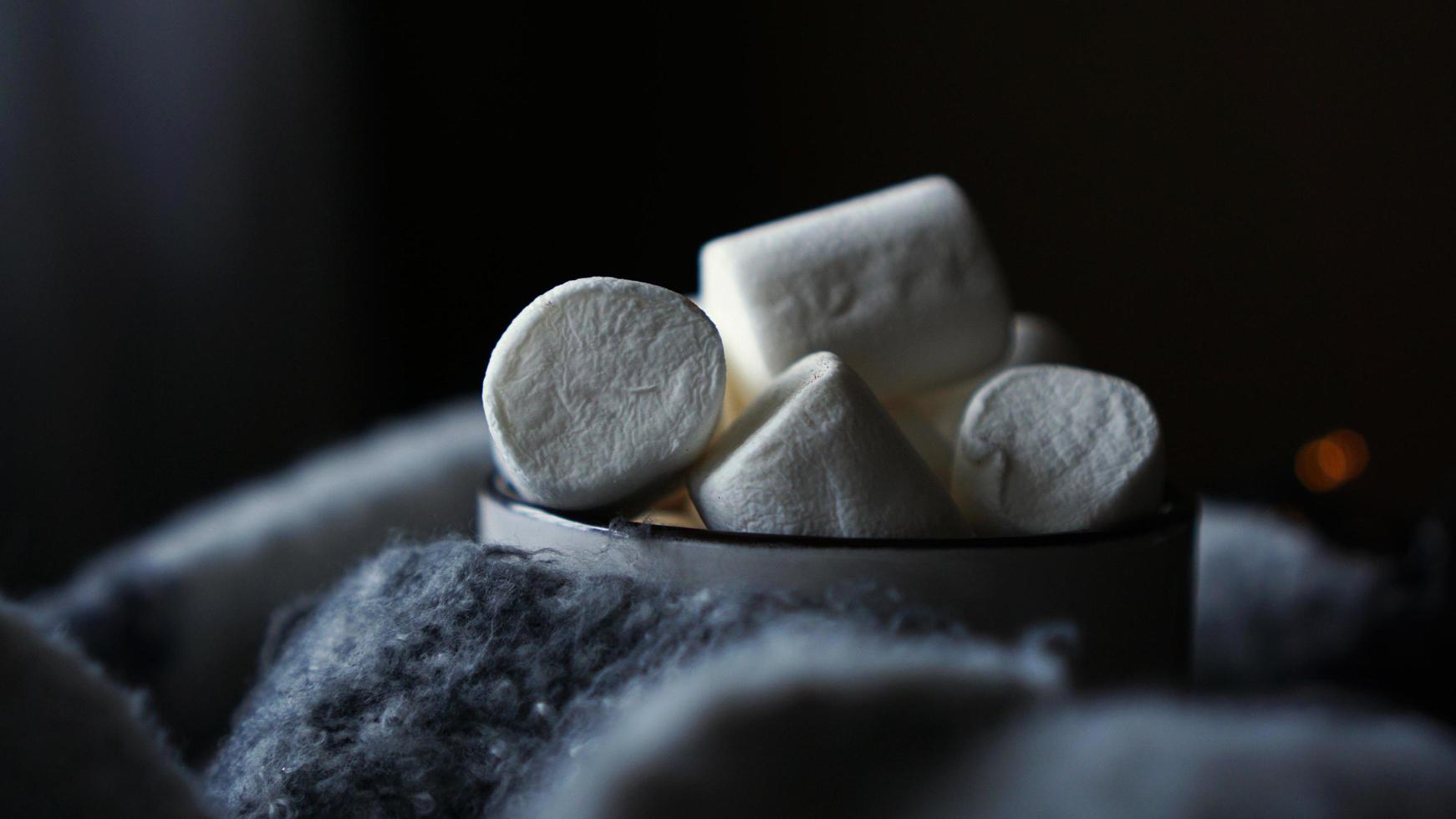 Hot cocoa with marshmallow in a white ceramic mug - dark background photo