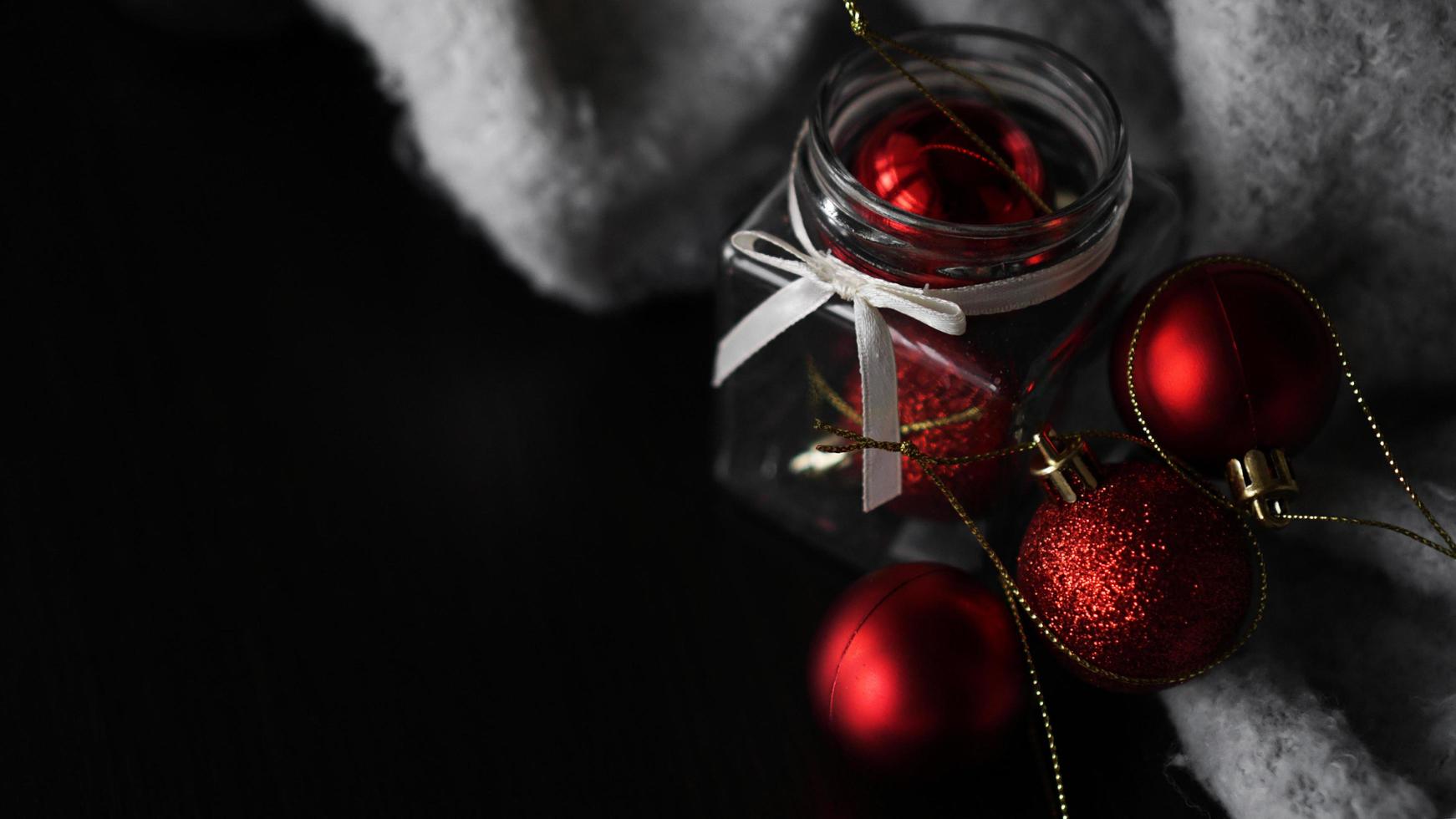 Small red Christmas balls in a glass jar photo