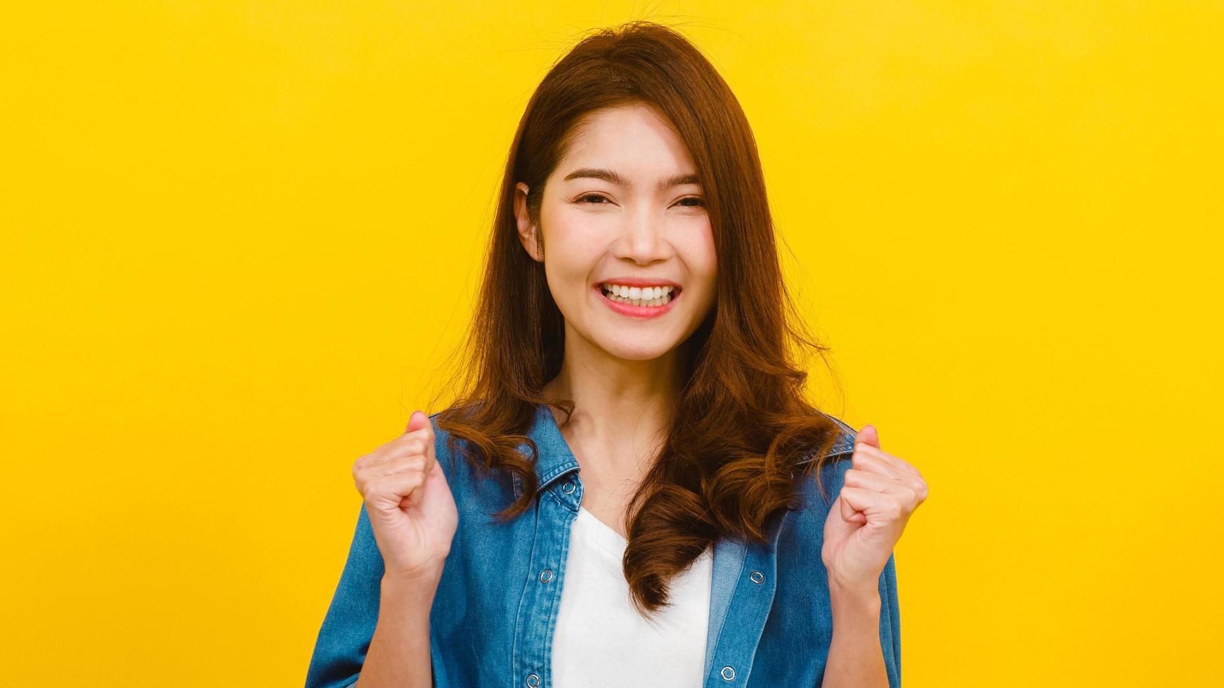 Asian female with positive expression over yellow background. photo