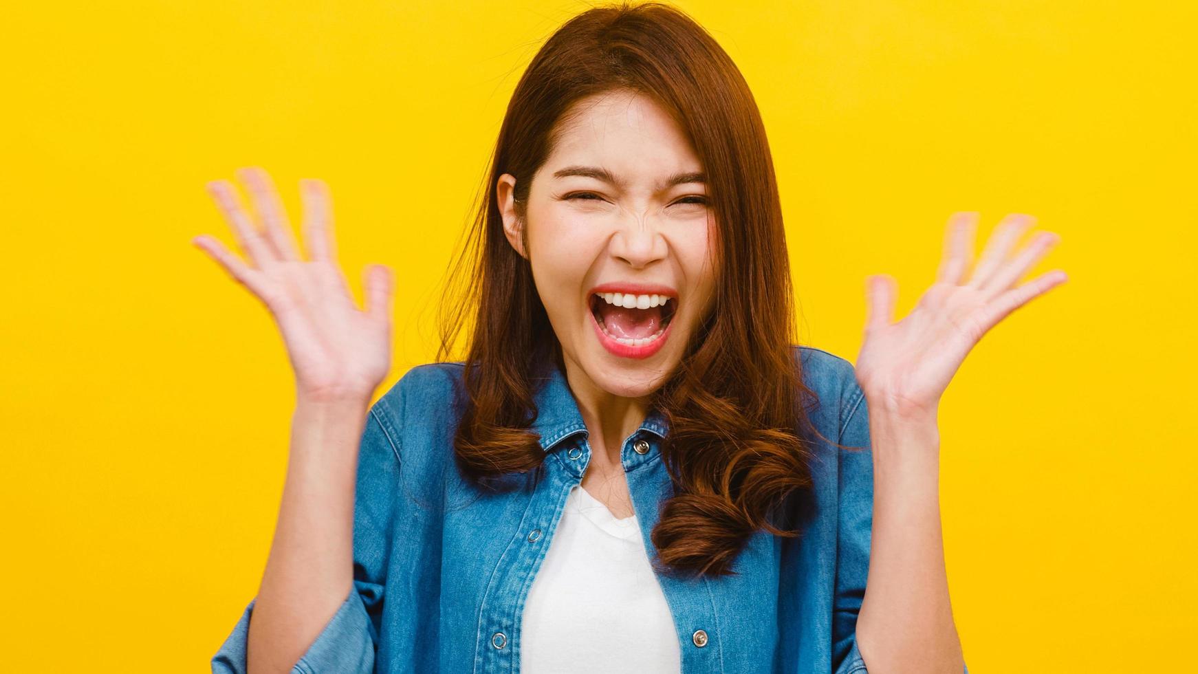 mujer asiática con expresión positiva sobre fondo amarillo. foto