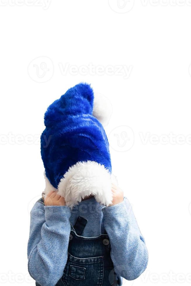 Funny little child in a Christmas hat isolated on a white background photo