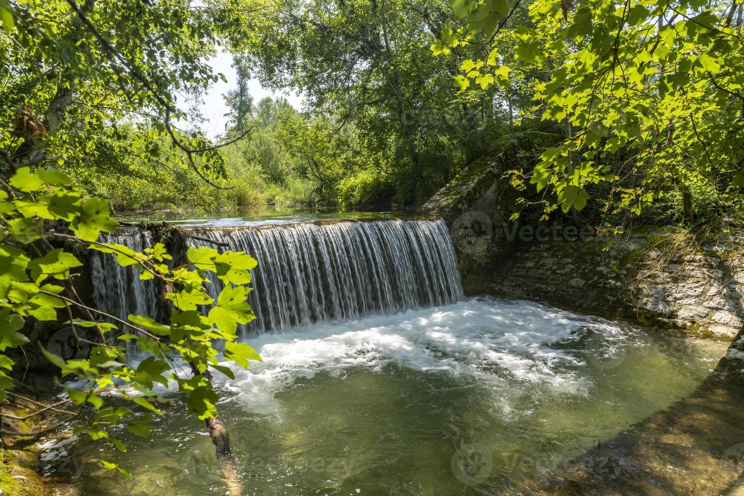 Waterfall at a barrage in the forest Chiemgau Germany photo