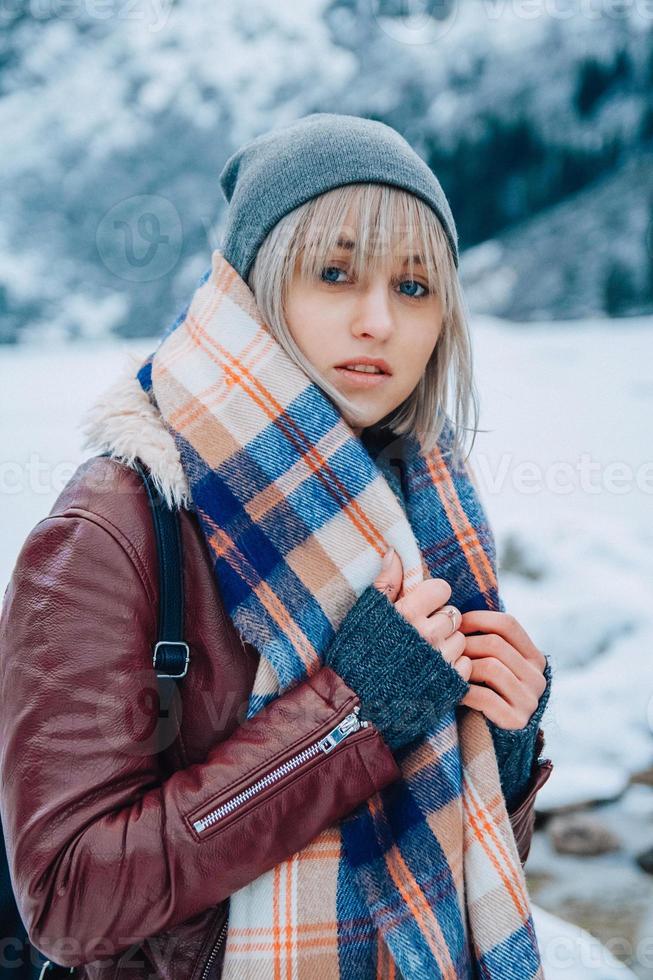 Portrait of girl in a hat with a scarf in the mountains in winter photo