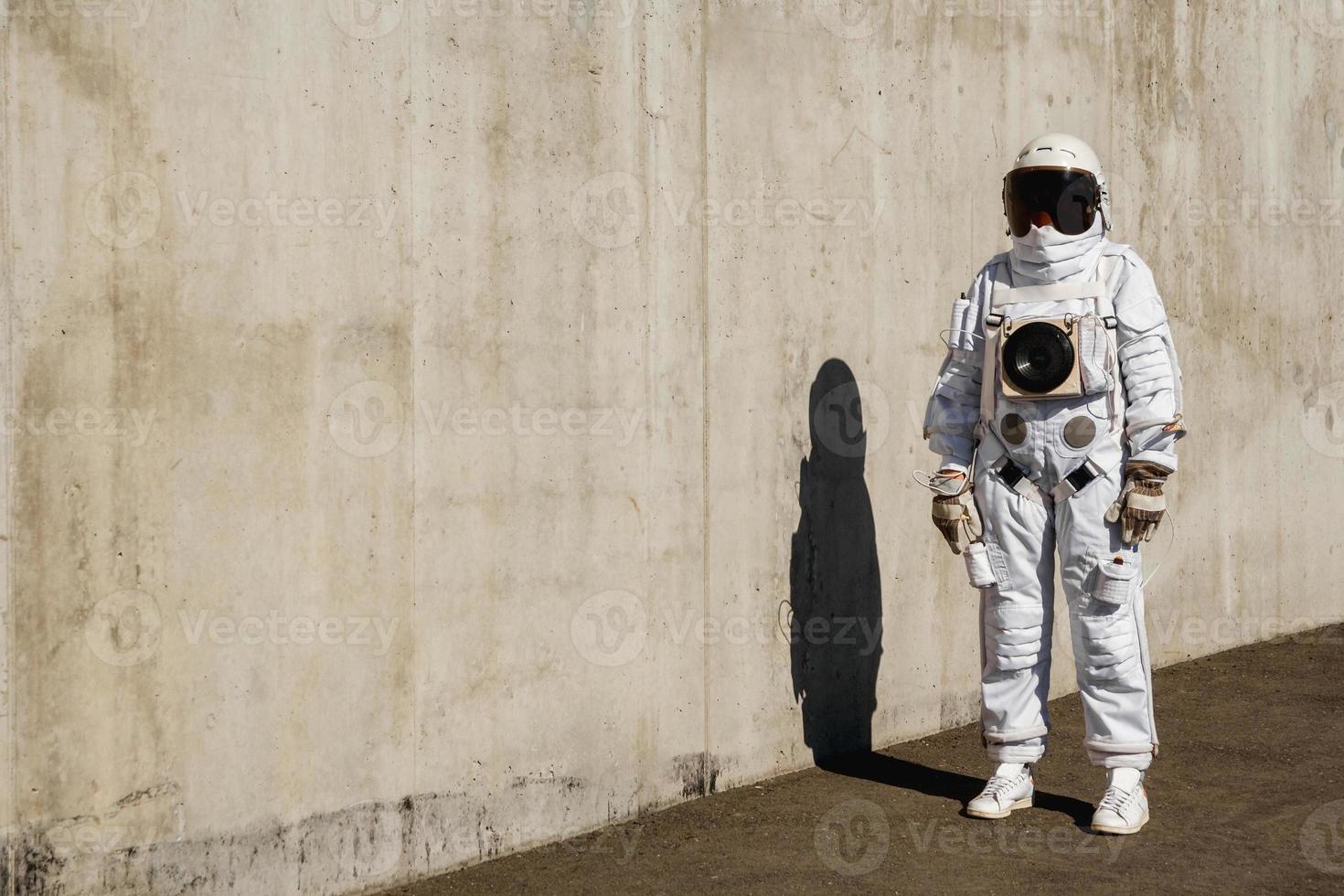 Futuristic astronaut in a helmet against gray walls photo