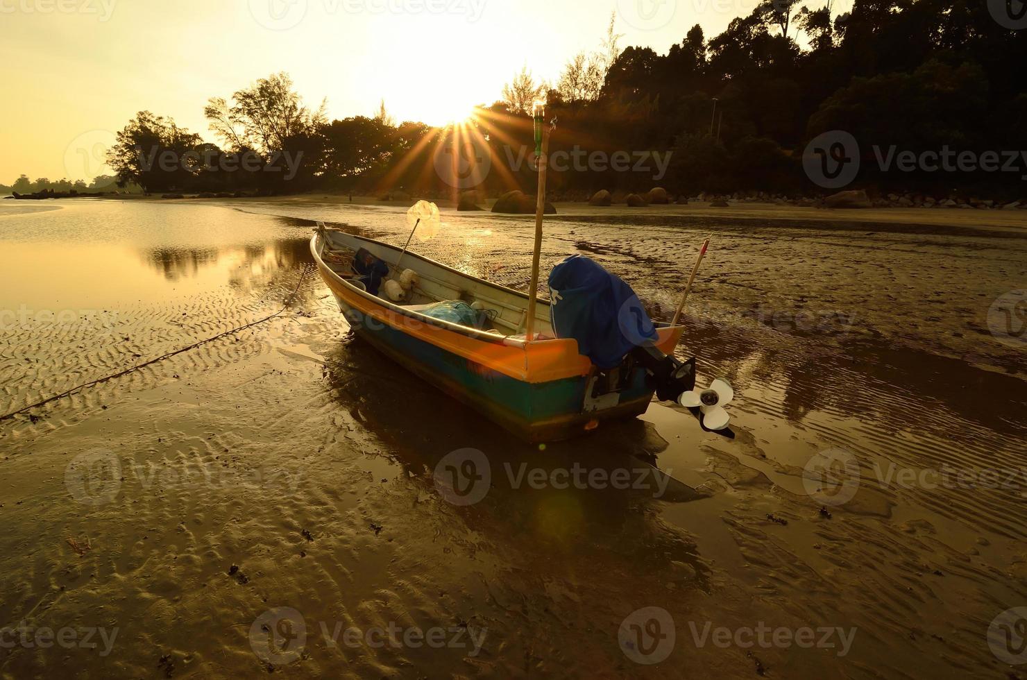 barco cerca de la playa cuando se pone el sol foto