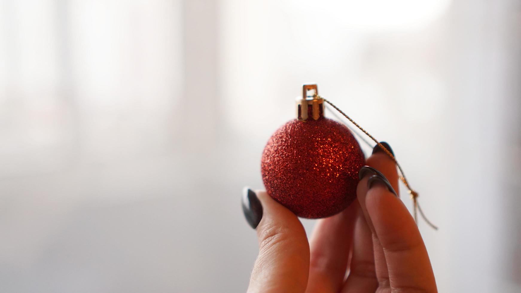 Christmas ball on hand with blurred background photo