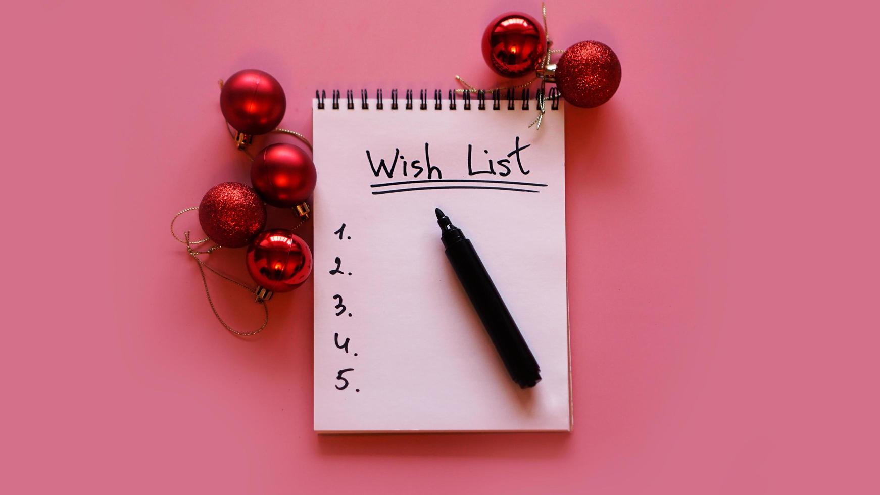 Notebook on pink background with christmas balls photo