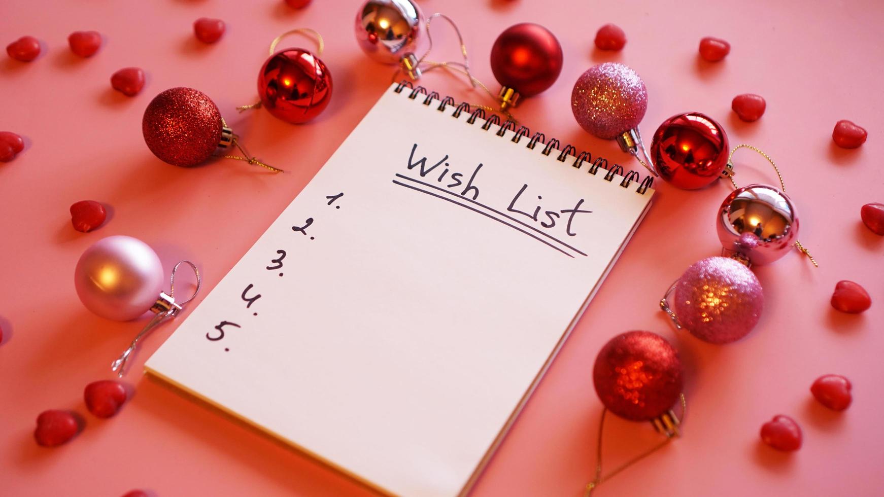 Notebook on pink background with christmas balls photo