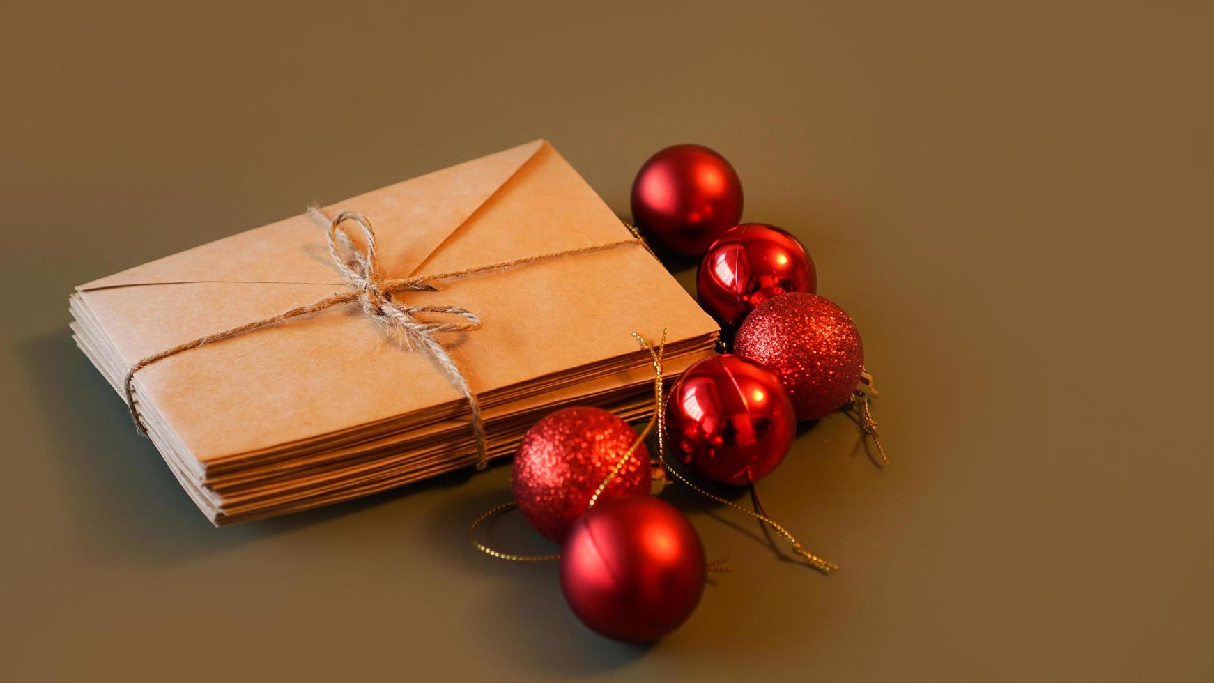 Christmas composition. Craft envelopes and red balls. Stack of letters photo