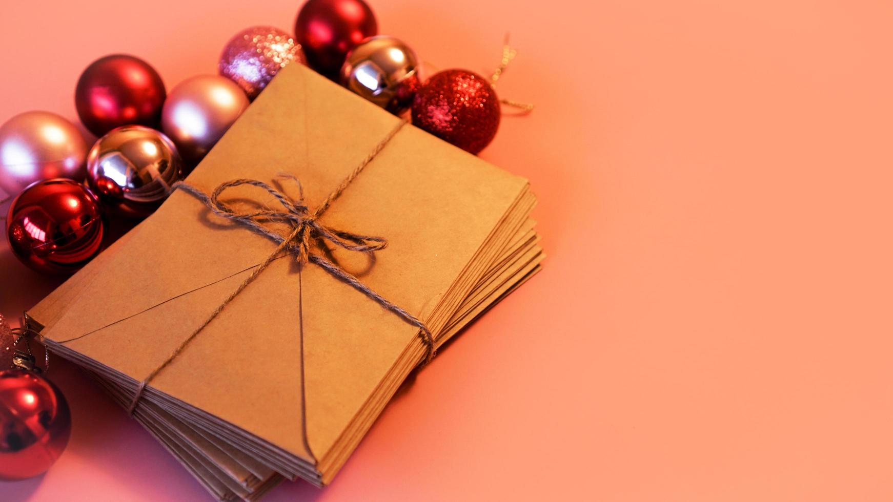 Stack of letters from craft paper with christmas red and pink balls photo