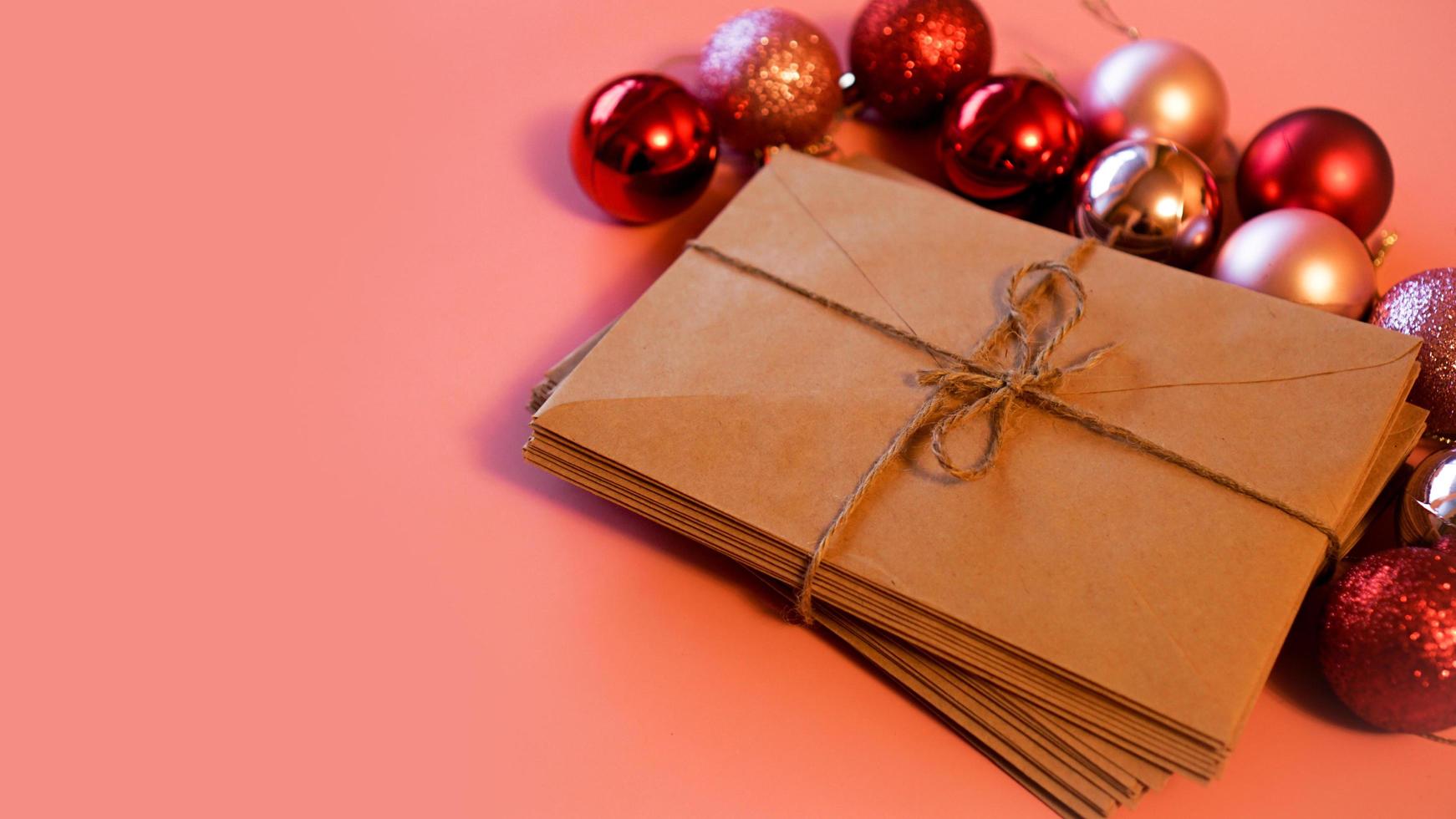 Stack of letters from craft paper with christmas red and pink balls photo