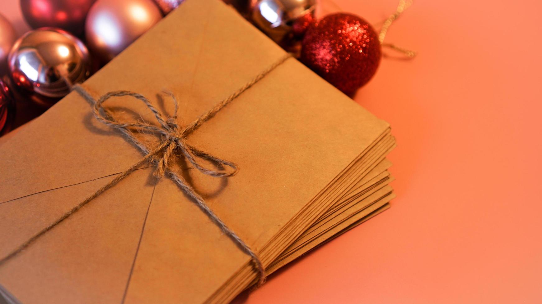 Stack of letters from craft paper with christmas red and pink balls photo