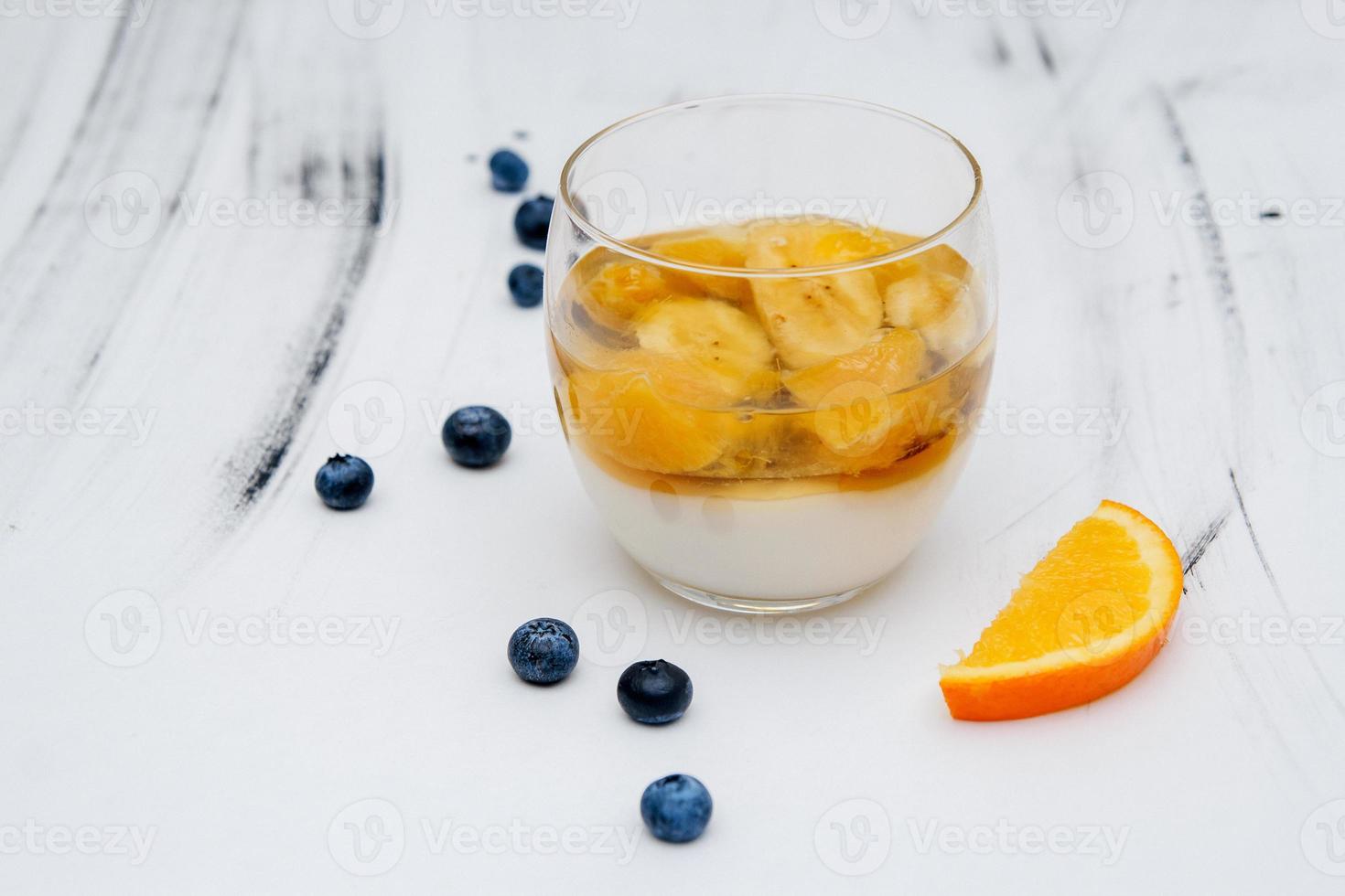 Colorful fruit jelly in a glass on a white background with blueberries photo