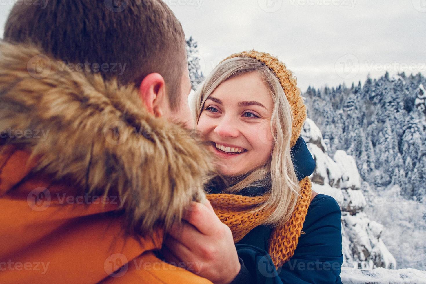 Loving couple cuddling outdoors in a snow landscape photo