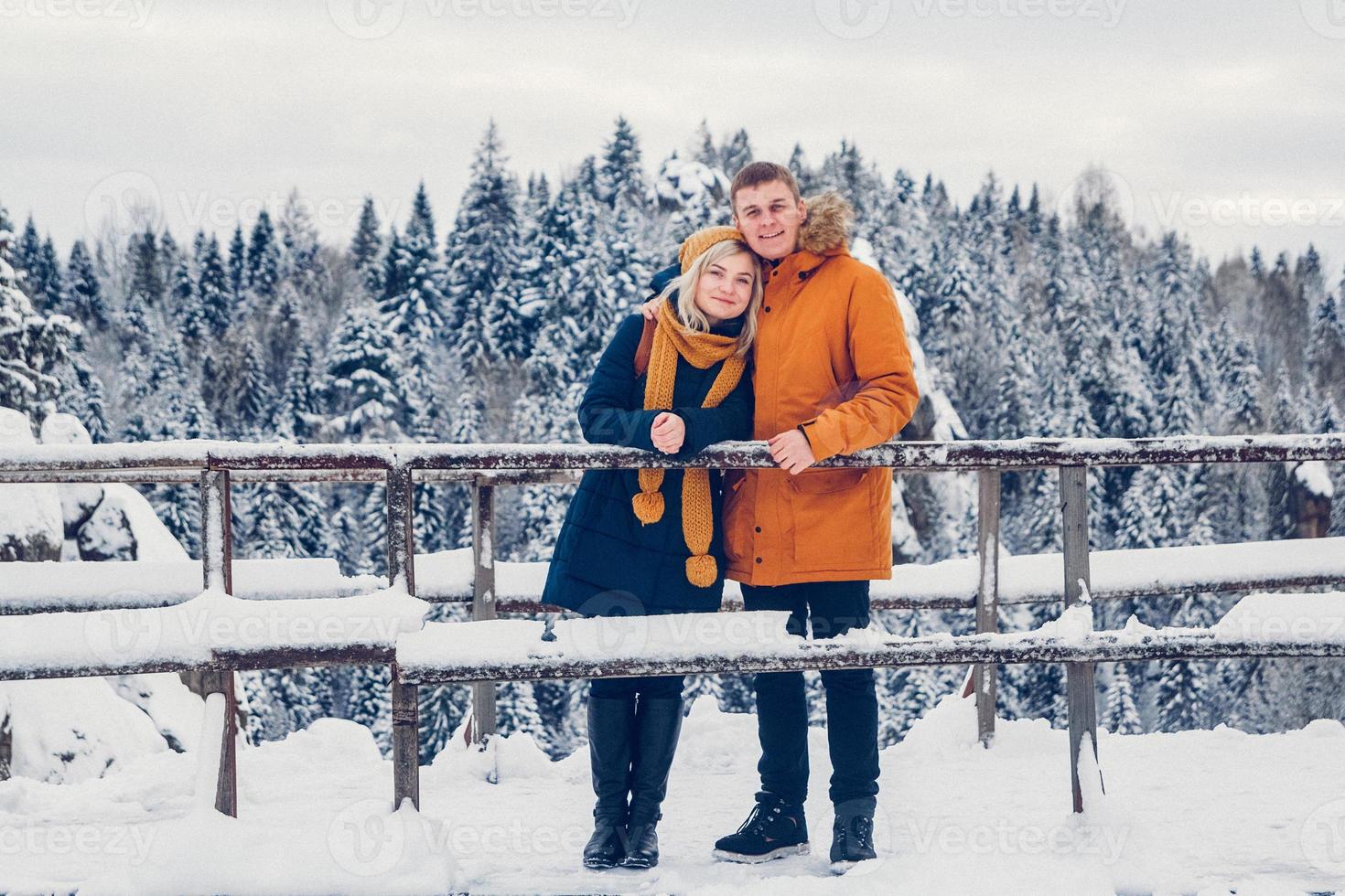 chico y chica caminan y se divierten en el bosque en invierno foto