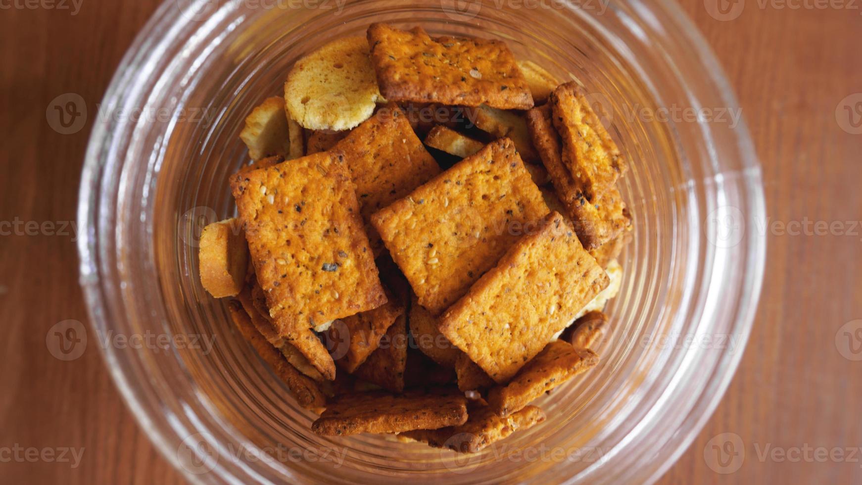 Wheat cracker in a glass jar on wooden table. photo