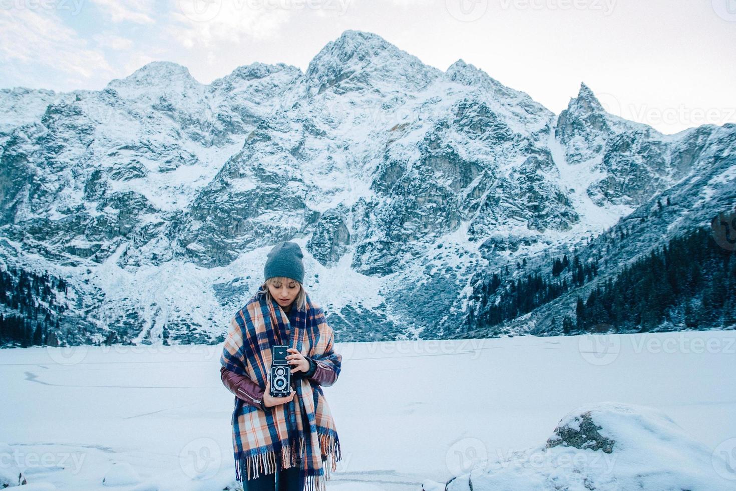 Girl with old vintage camera on a background of snow mountains photo