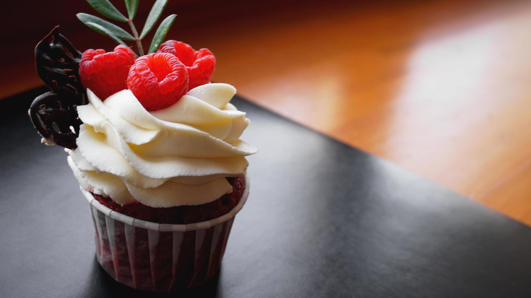 Delicious raspberry cupcakes on dark background photo