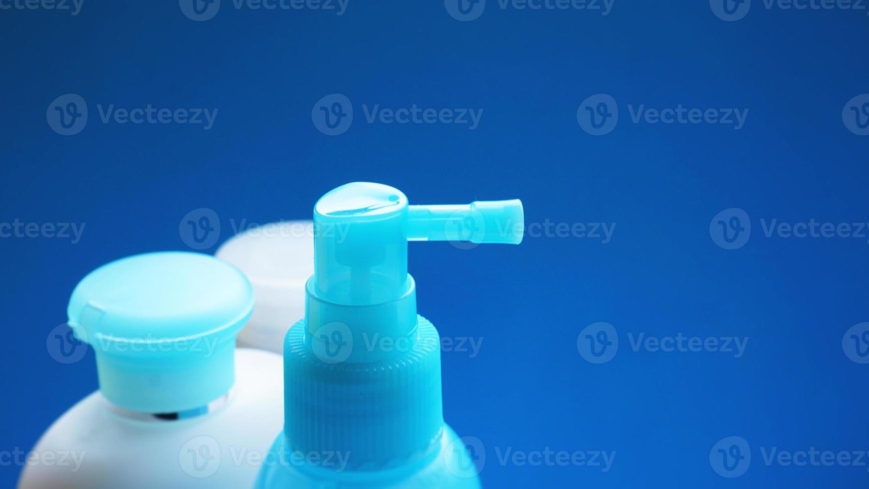 Blue cosmetic tube on blue background. Blank plastic container photo