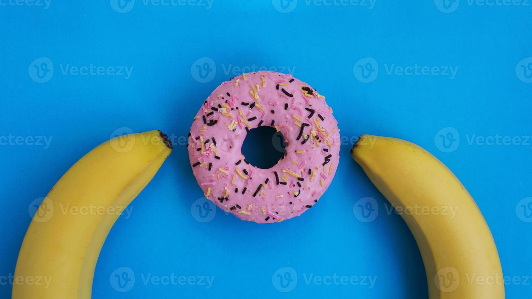 dos plátanos y un fondo azul rosquilla rosa. concepto erótico foto