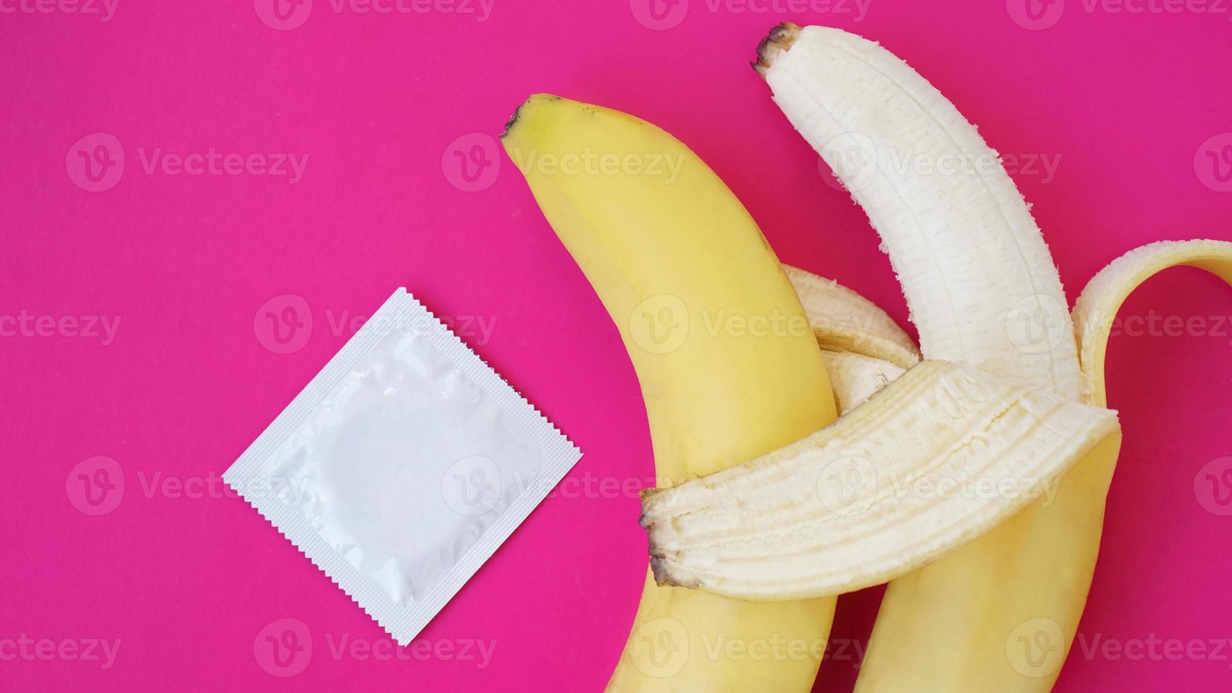 Condoms and two bananas together, concept of contraceptives photo