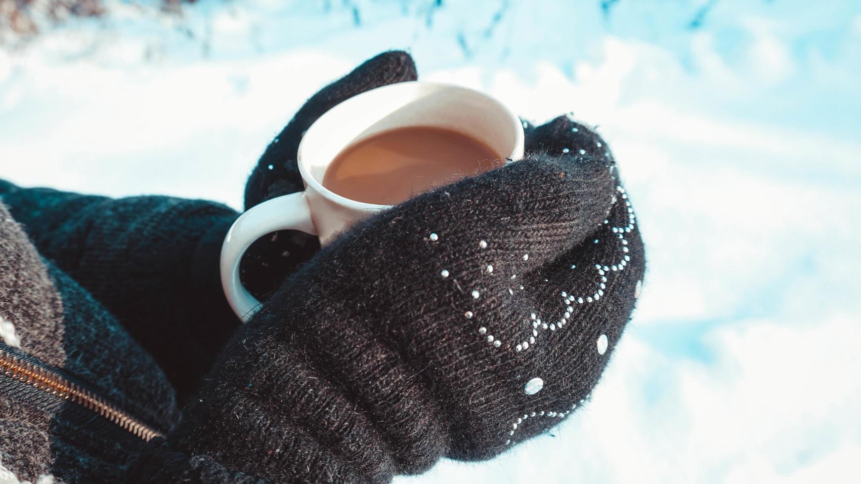 taza de café caliente calentándose en las manos de una niña foto