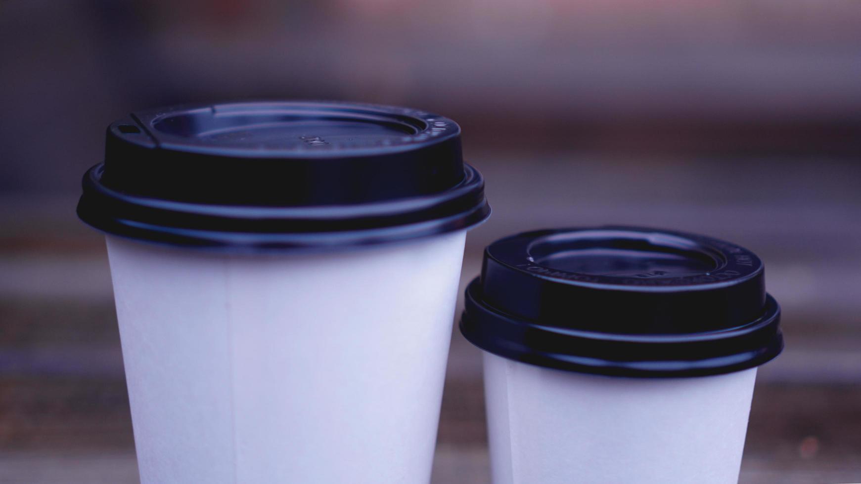 Coffee paper craft cup stands on wooden surface photo