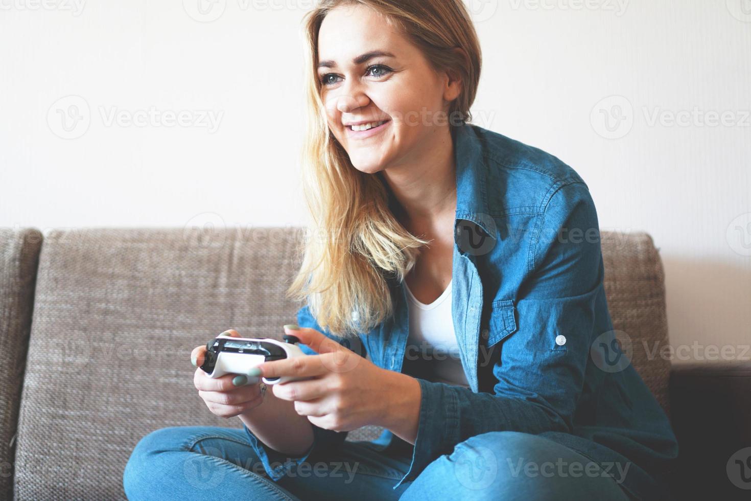 Girl gamer plays with wireless gamepad photo