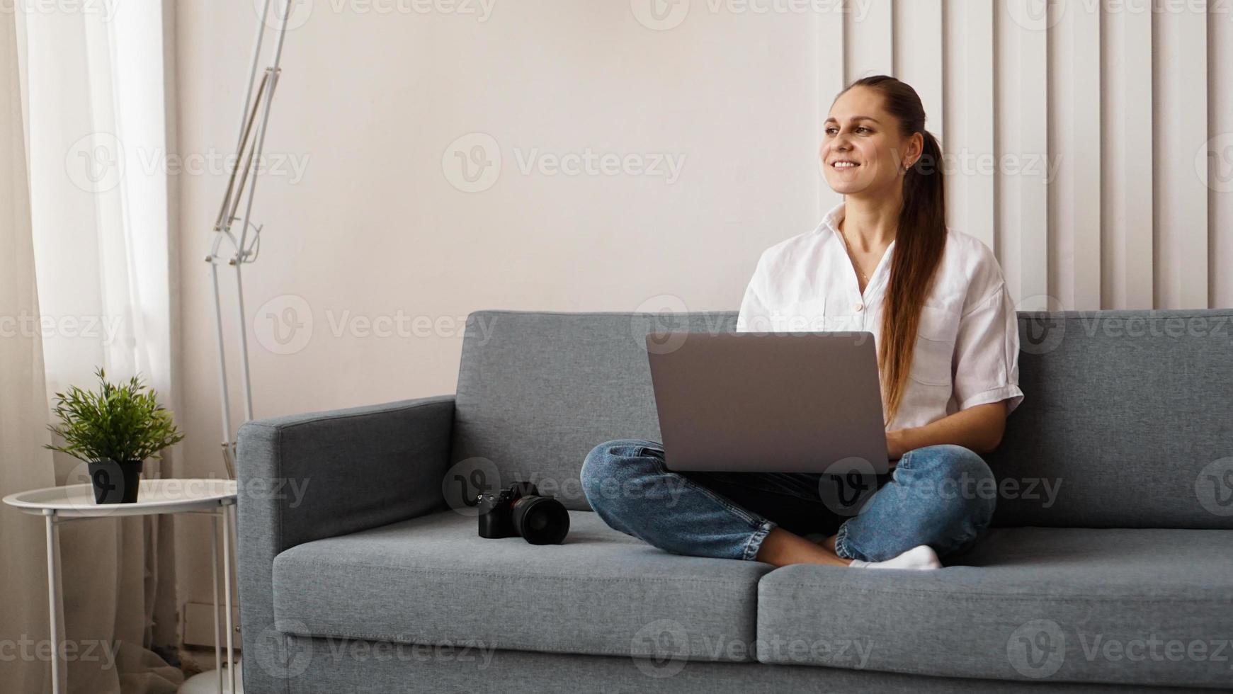 mujer joven feliz usando la computadora portátil en casa foto