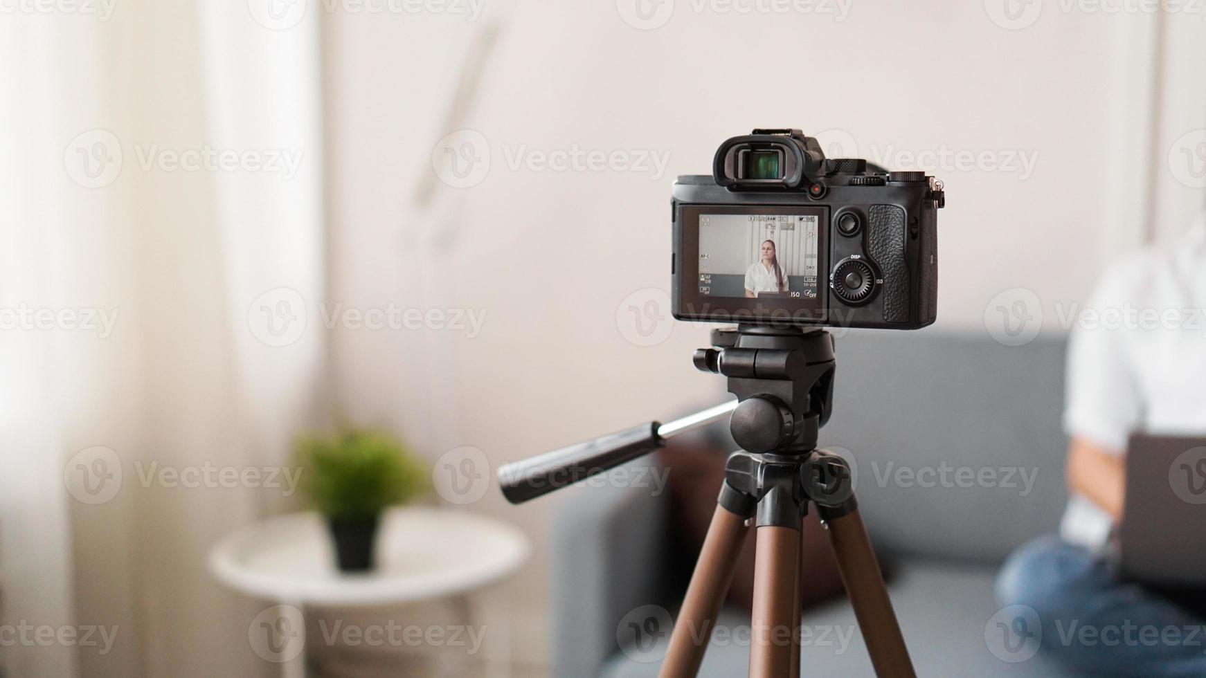 Blogger grabando video en interiores, enfoque selectivo en la pantalla de la cámara foto