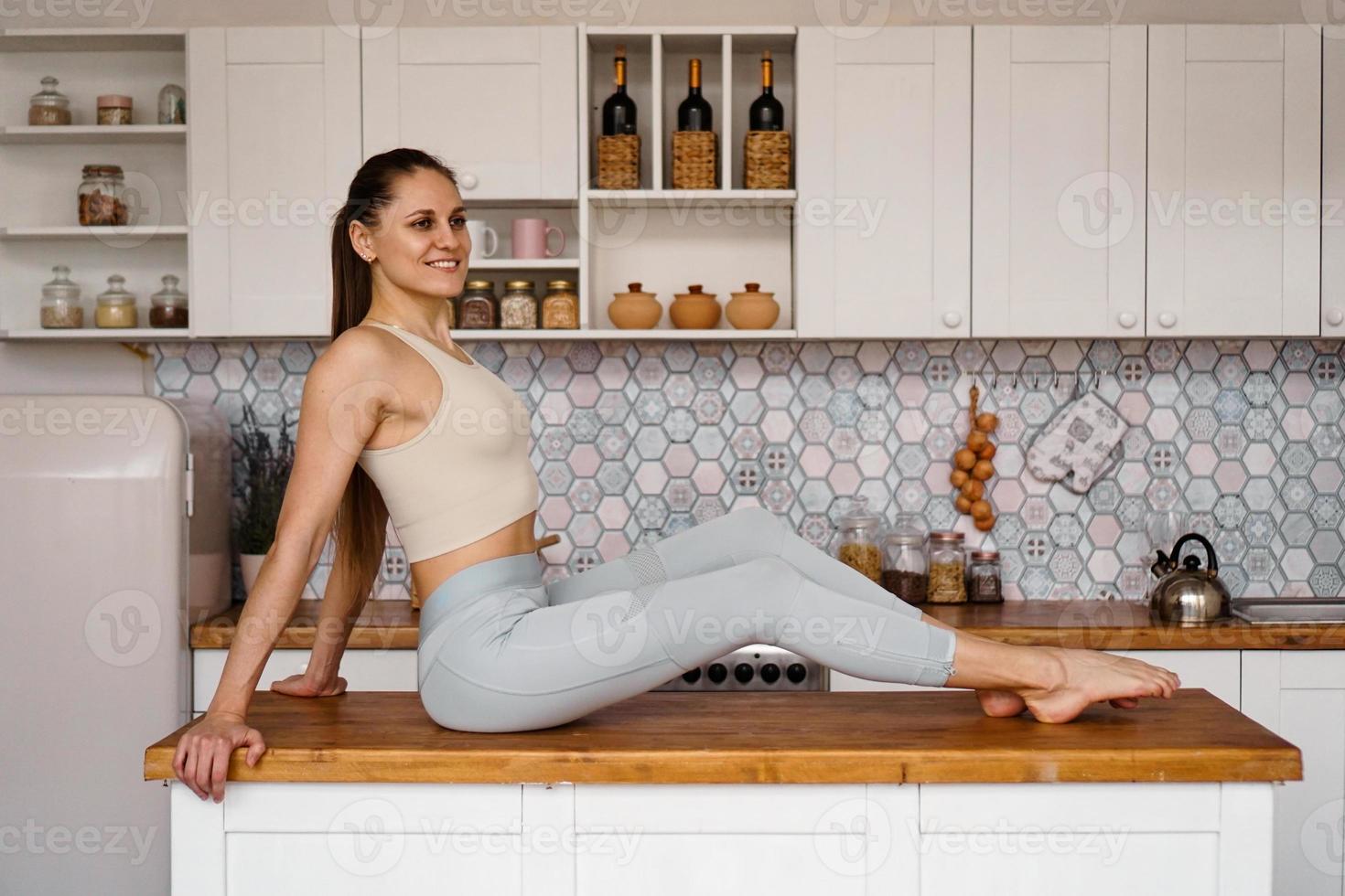 Athletic woman in sportswear posing on the table photo