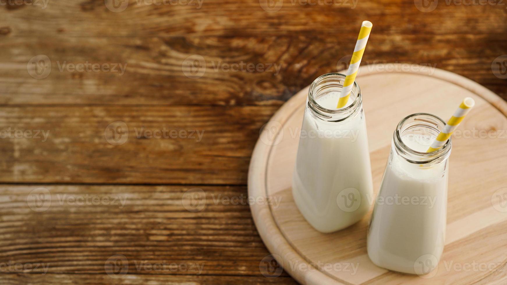 Dos botellas de leche orgánica rústica sobre mesa de madera foto