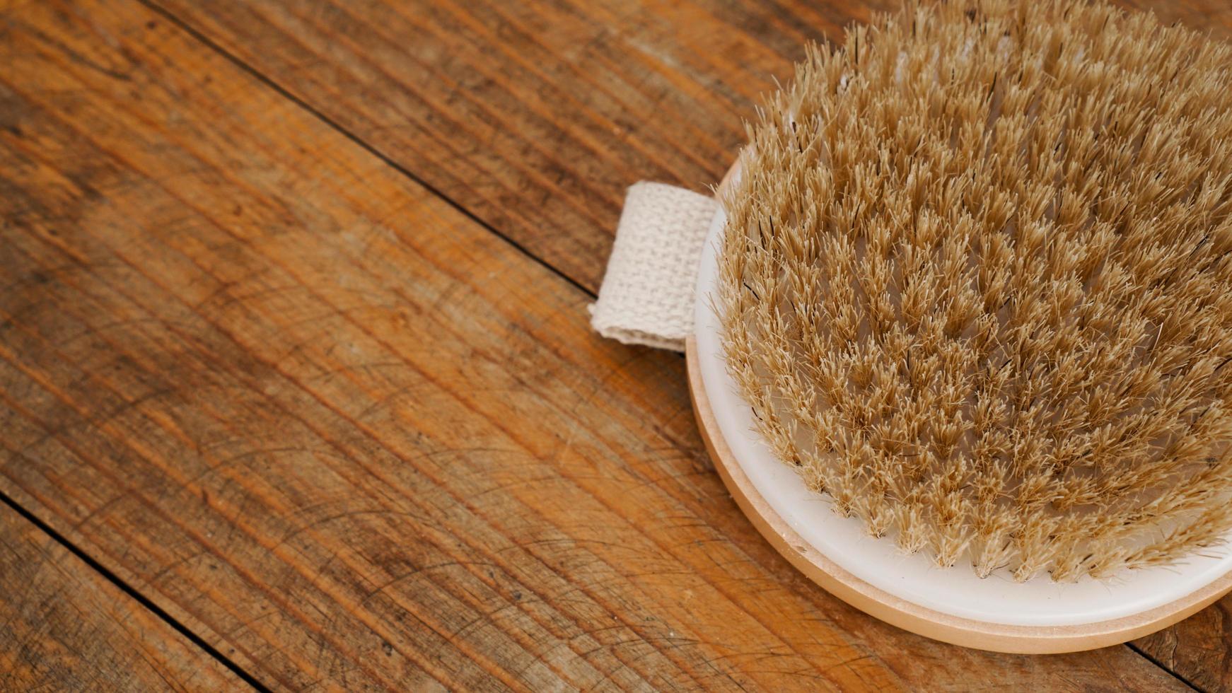 Dry massage brush made of natural materials on a wooden background photo