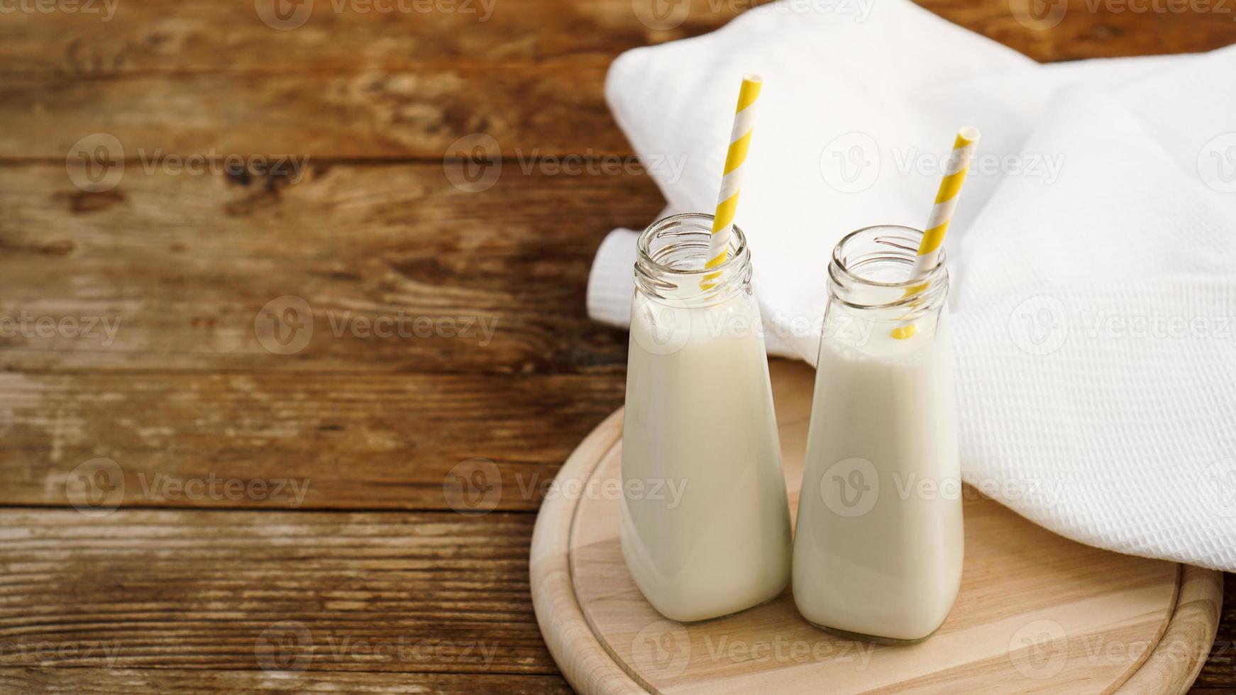 Dos botellas de leche orgánica rústica sobre mesa de madera foto