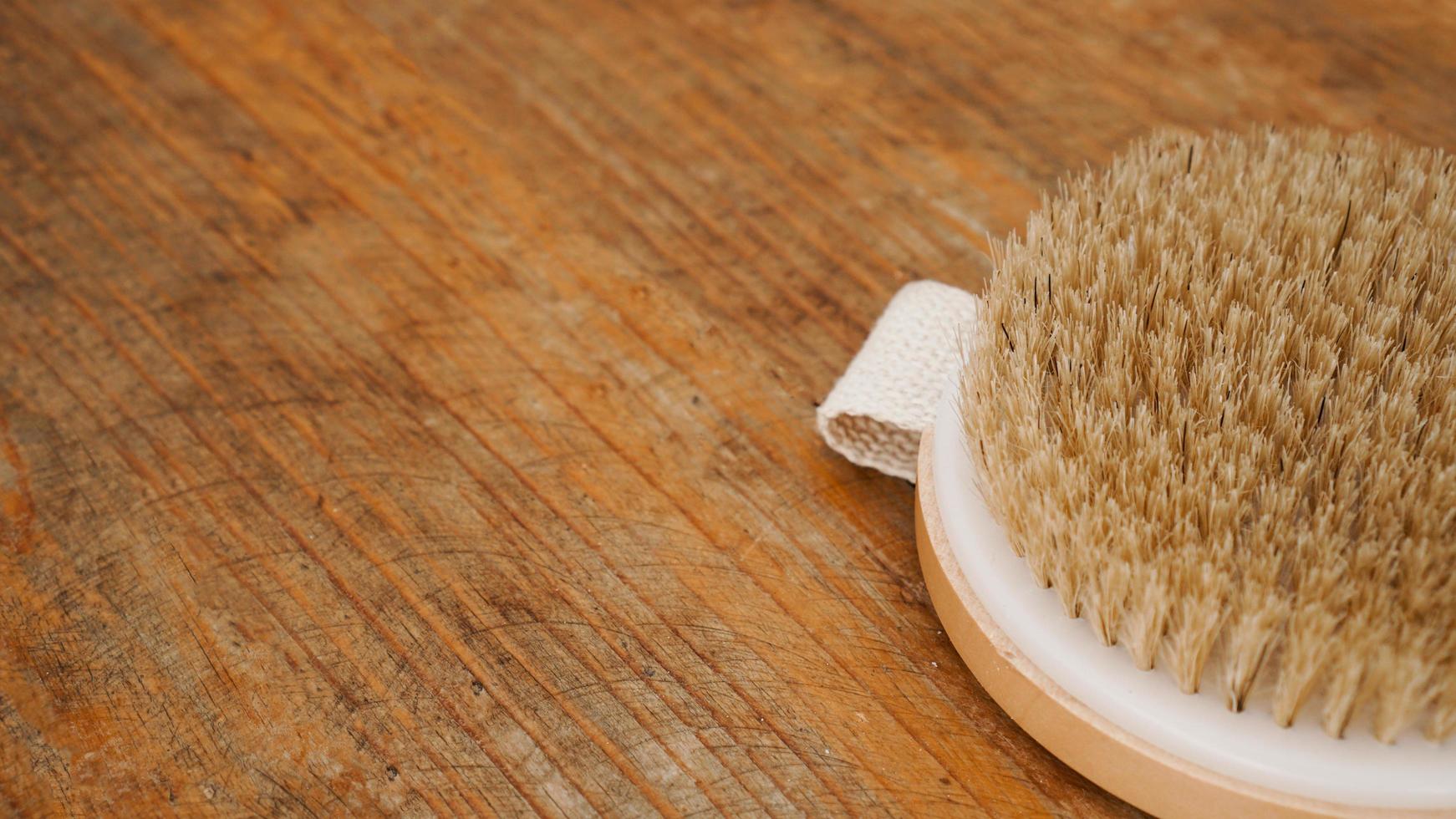 Dry massage brush made of natural materials on a wooden background photo