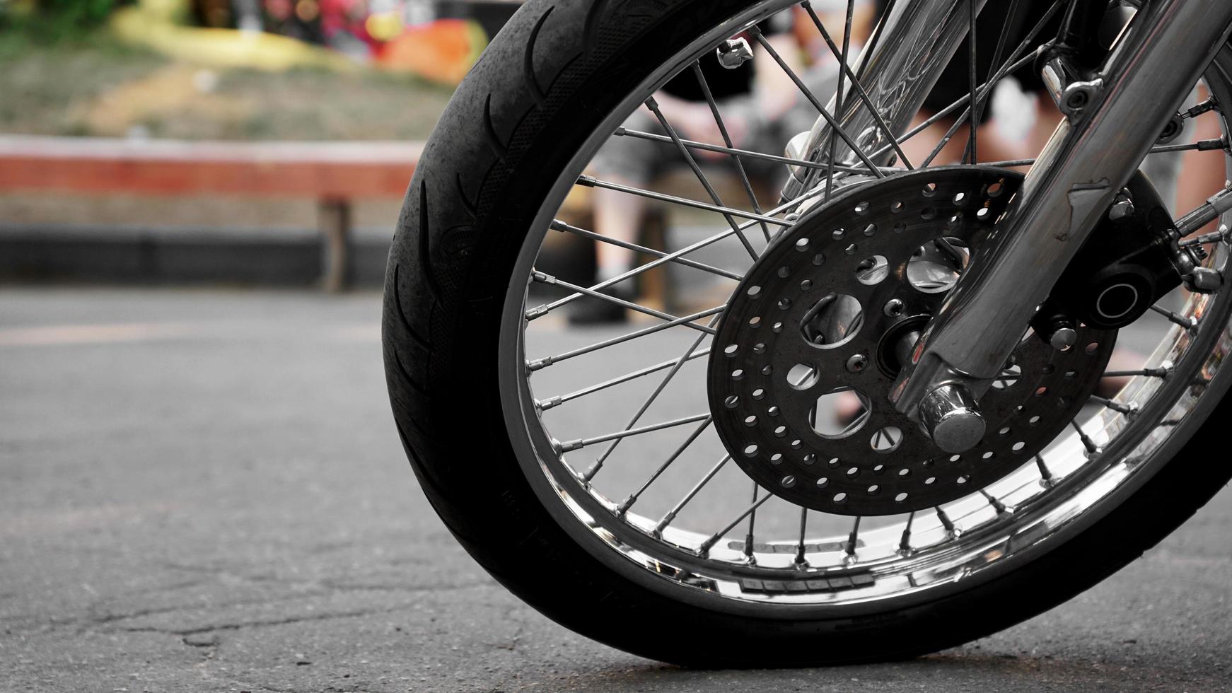 Primer plano de la rueda de la motocicleta sobre un fondo borroso. rueda sobre asfalto foto