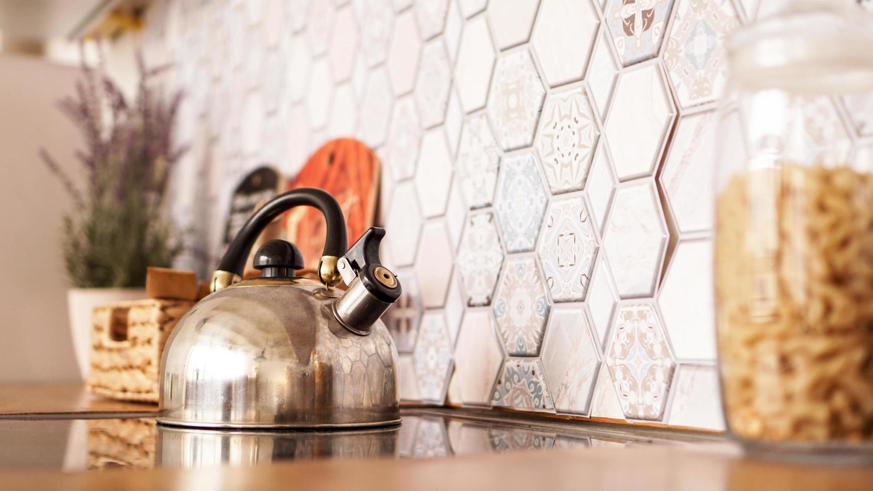 Metal kettle on the stove. Modern cozy kitchen photo