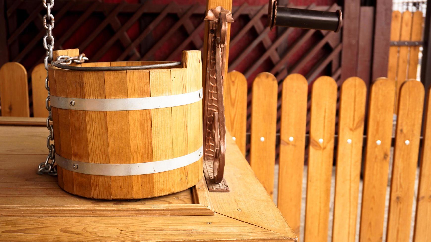 Rural wooden well. Close up photo of a wooden bucket.