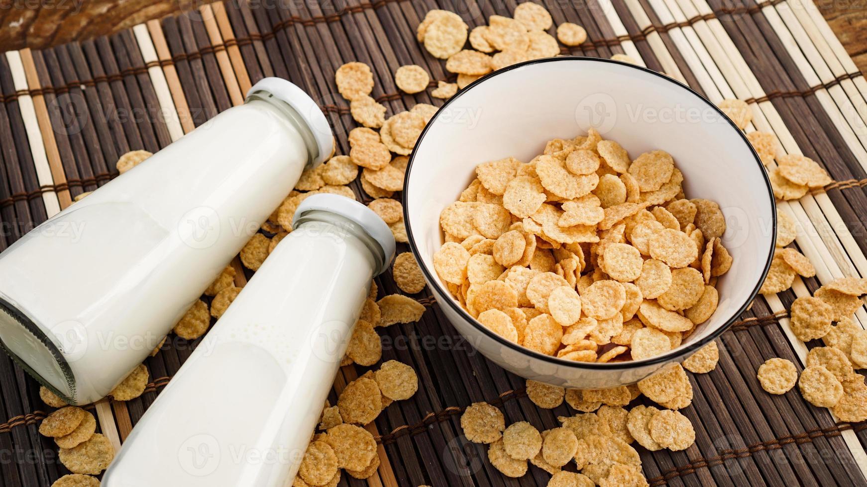 copos de maíz saludables y leche en una servilleta de bambú. foto