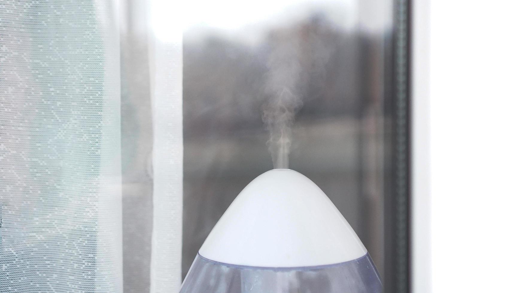 El humidificador ultrasónico blanco en una ventana de la sala de estar foto